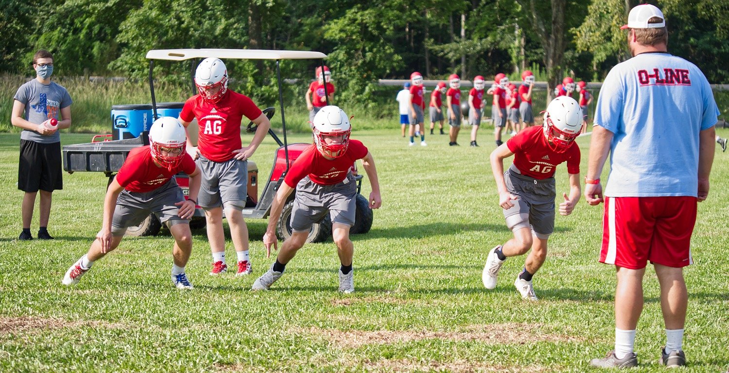 Alba-Golden linemen get in some drills during Tuesday morning practices under the eye of Coach Bobby Wells.